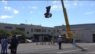 軽トラックをクレーン車で吊り上げた様子