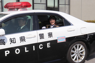 パトカーに乗って出発する様子