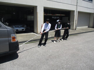 ロープを使って車両を人力で移動させている様子